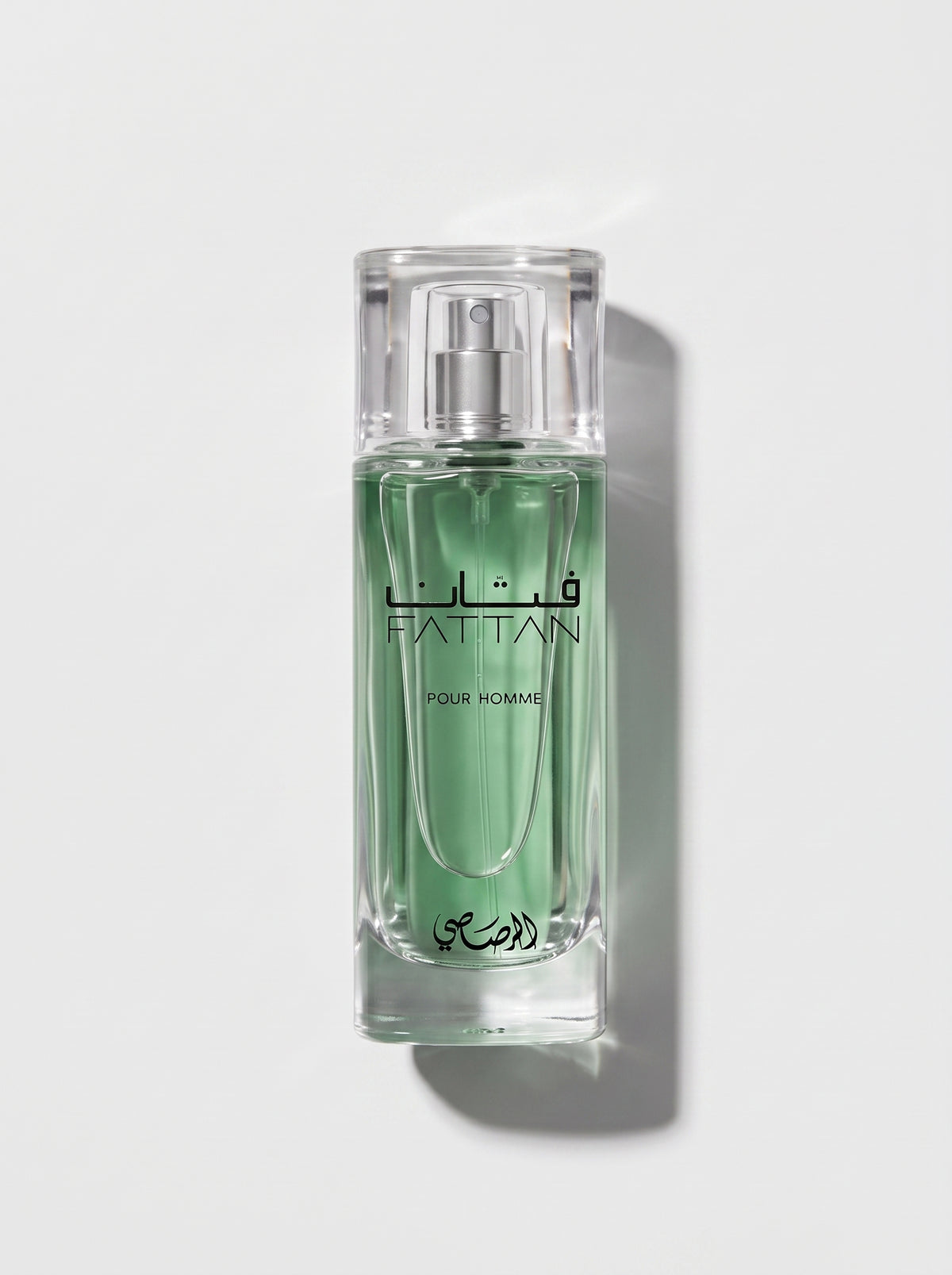 Rasasi Fattan — clear glass bottle of pale green juice with a clear cap, FATTAN Pour Homme, top-down