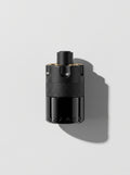 Azzaro Most Wanted — matte black cylinder with a knurled band and gold-topped studs, top-down