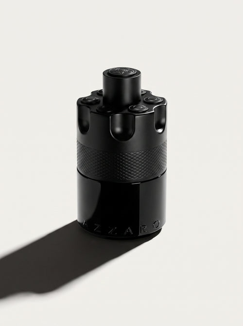 Azzaro Most Wanted — the black studded cylinder upright at eye level, knurled band and AZZARO embossing in view
