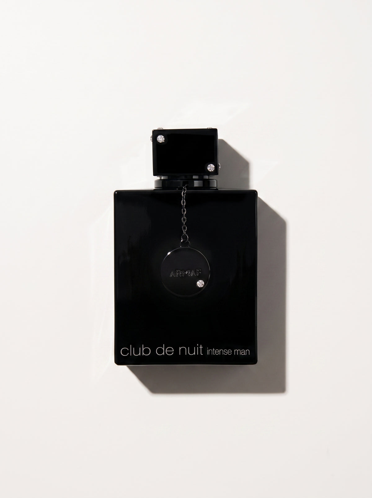 Club de Nuit Intense Men Pure Perfume — gloss black rectangular bottle with a chained round medallion, top-down