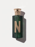Naseem Lost In The Woods — deep green glass bottle with a rose-gold cap and a large gold N, top-down