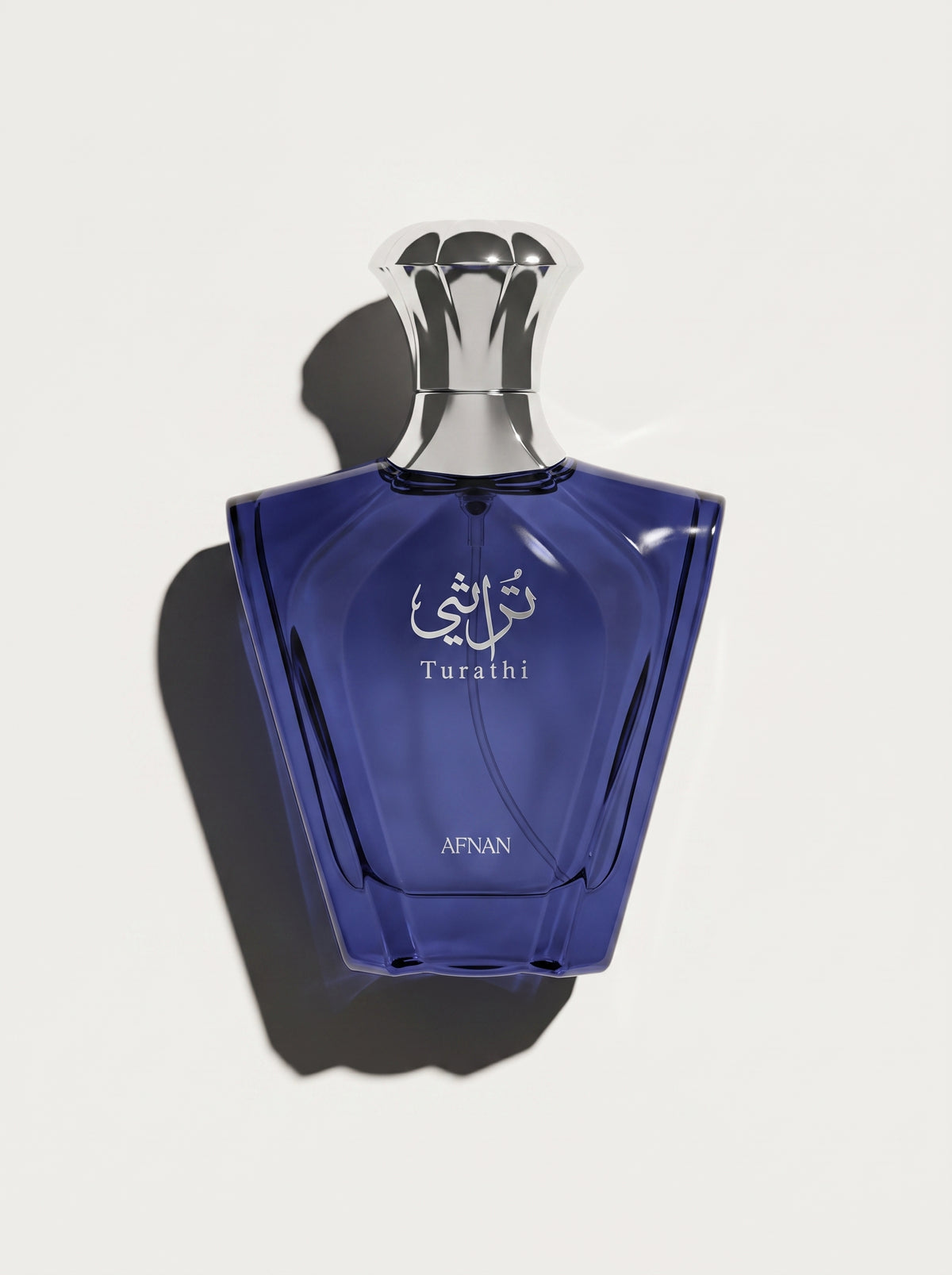 Turathi Blue by Afnan — deep blue faceted fan-shaped bottle with a silver crown cap, top-down