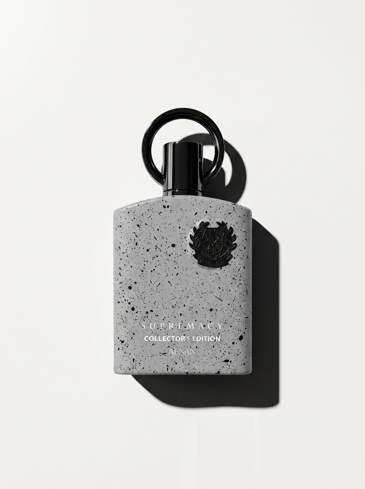 Supremacy Collector's Edition — grey speckled stone-effect bottle with a black crest and ring cap, top-down